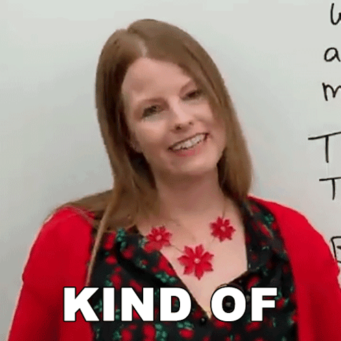 A Woman Wearing A Red Sweater And A Necklace With Red Flowers Is Smiling And The Words Kind Of Are Above Her GIF