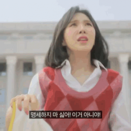 a woman wearing a red vest and a white shirt is holding a yellow object .