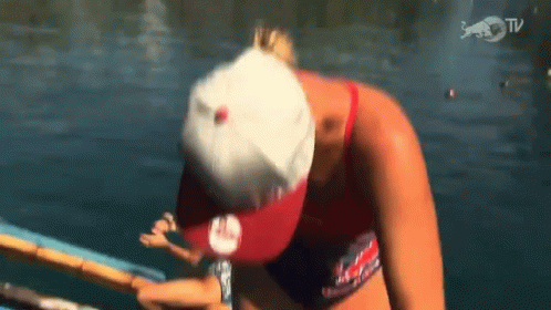 A Woman Wearing A Red White And Blue Hat Is In The Water GIF