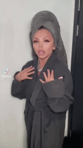 A Woman Wearing A Robe And A Towel On Her Head . GIF