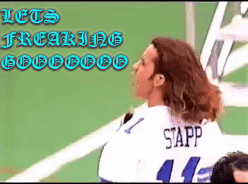 A Woman Wearing A Sapp Jersey Stands In Front Of A Green Wall GIF
