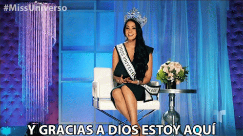 A Woman Wearing A Sash That Says Miss Universe Is Sitting In A Chair GIF