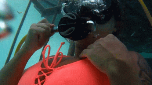 A Woman Wearing A Scubapro Mask Is Swimming In The Water GIF