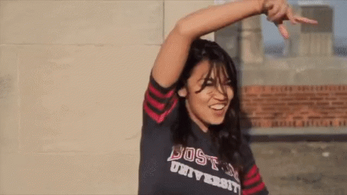 A Woman Wearing A Shirt That Says Boston University Is Smiling GIF