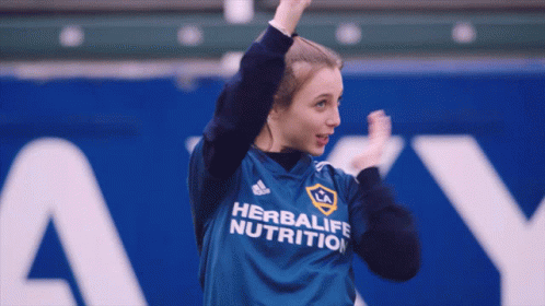 A Woman Wearing A Shirt That Says Herbalife Nutrition On It GIF