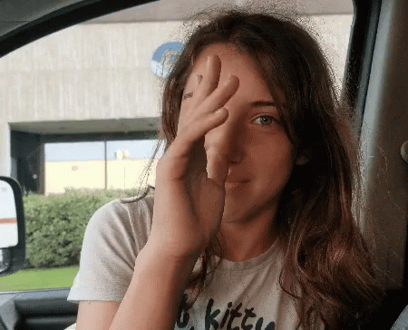 A Woman Wearing A Shirt That Says Kitty Covering Her Face GIF