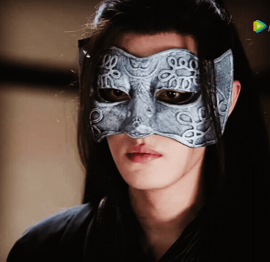 A Woman Wearing A Silver Mask With A Pattern Of Circles On It GIF