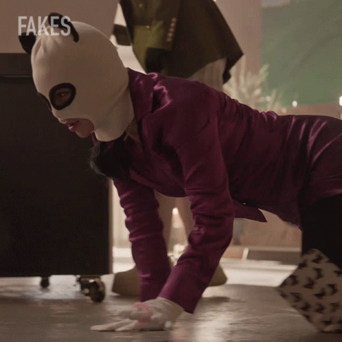 A Woman Wearing A Ski Mask Is Doing Push Ups In Front Of A Fakes Logo GIF