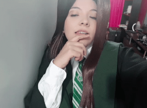 A Woman Wearing A Slytherin Uniform Takes A Selfie With Her Hand On Her Chin GIF