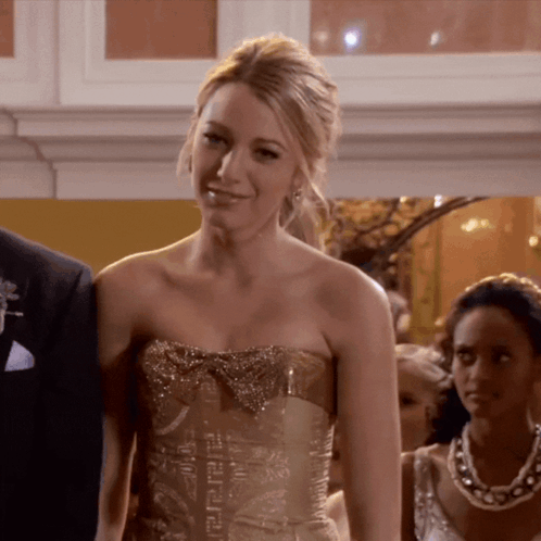 A Woman Wearing A Strapless Gold Dress With A Bow GIF