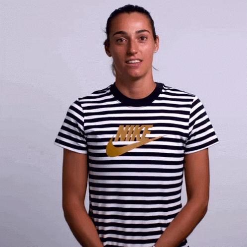 A Woman Wearing A Striped Nike Shirt Smiles GIF