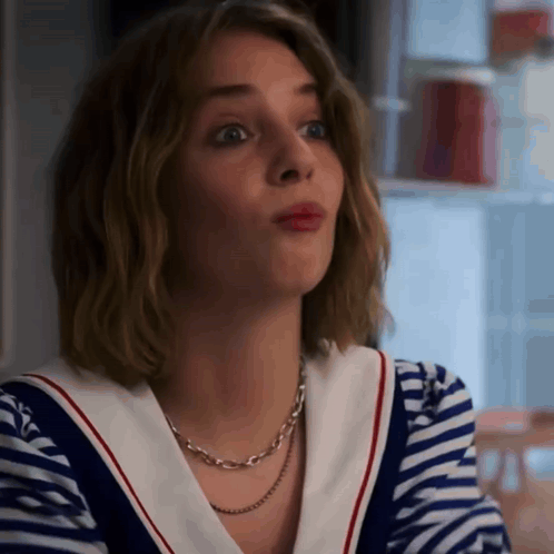 A Woman Wearing A Striped Shirt And A Necklace Looks Surprised GIF