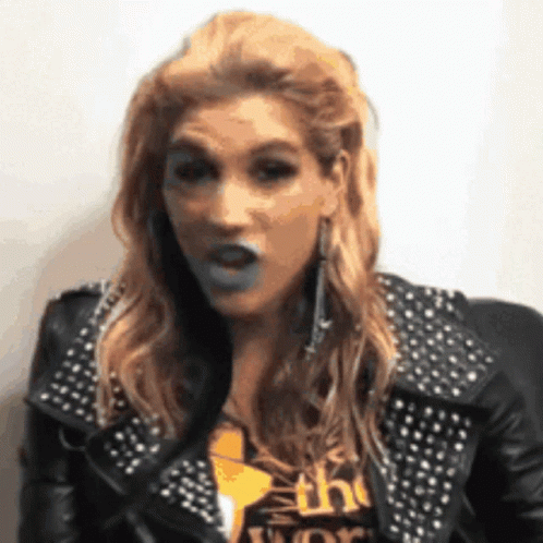 A Woman Wearing A Studded Leather Jacket Is Making A Face GIF