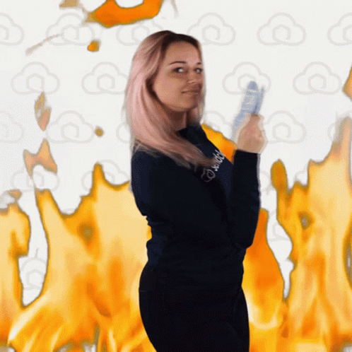 A Woman Wearing A Sweatshirt That Says ' Daddy ' On It Stands In Front Of Flames GIF