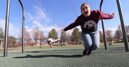 A Woman Wearing A Sweatshirt That Says ' Faith ' On It Is Swinging On A Swing Set GIF