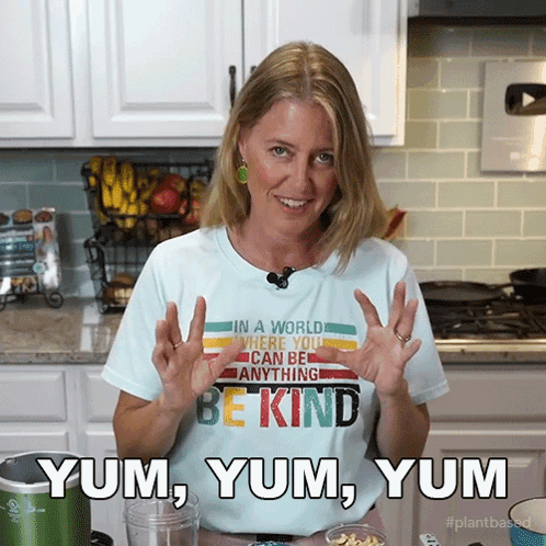 A Woman Wearing A T-Shirt That Says Be Kind Yum Yum Yum GIF