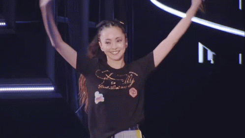 A Woman Wearing A T-Shirt That Says Finally Is Standing On Stage GIF