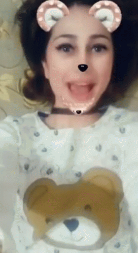 A Woman Wearing A Teddy Bear Sweater Is Making A Face GIF