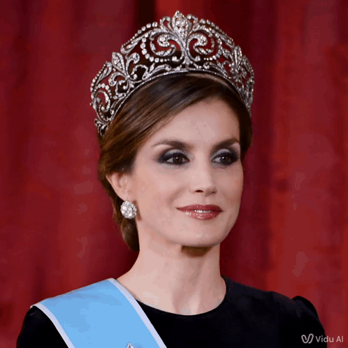 A Woman Wearing A Tiara And A Blue Sash With The Word Vida On The Bottom GIF