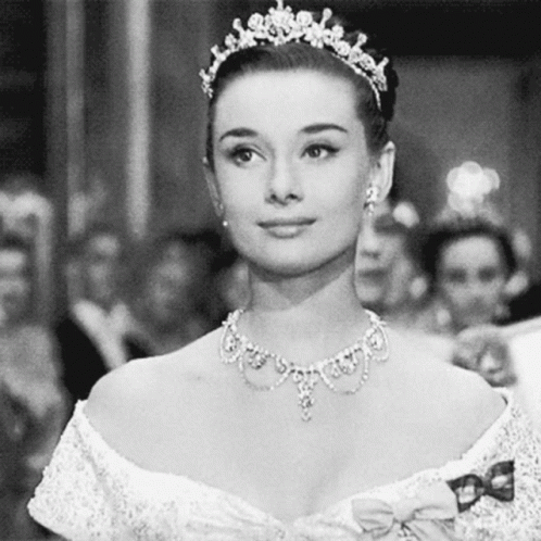 Smiling Woman Wearing Tiara And Necklace In Black And White GIF
