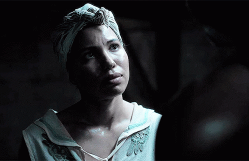 A Woman Wearing A Turban And A White Shirt Looks Up At Something GIF