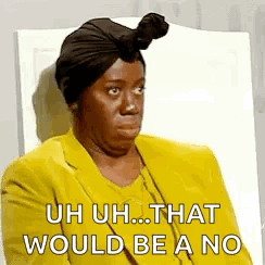A Woman Wearing A Turban And A Yellow Jacket Is Sitting In A Chair And Making A Funny Face . GIF