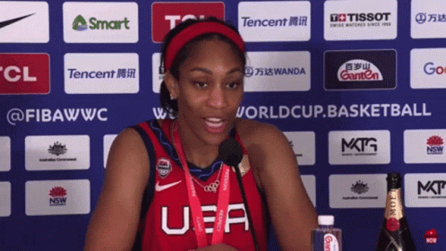 A Woman Wearing A U.s.a. Jersey Stands In Front Of A Wall Of Sponsors GIF