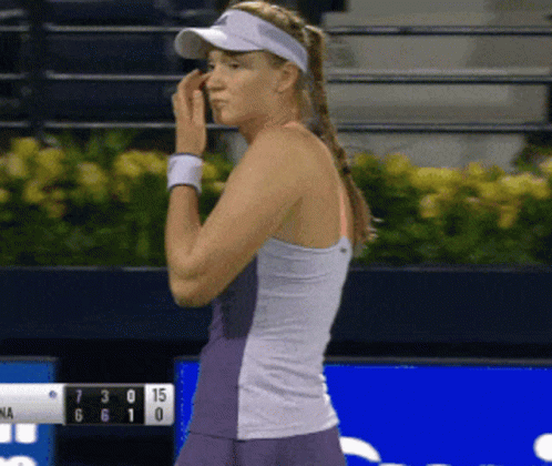 A Woman Wearing A Visor Is Standing In Front Of A Scoreboard That Shows The Score Of 7 To 15 GIF