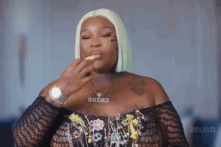 A Woman Wearing A Watch And A Necklace With The Word Baddies On It . GIF