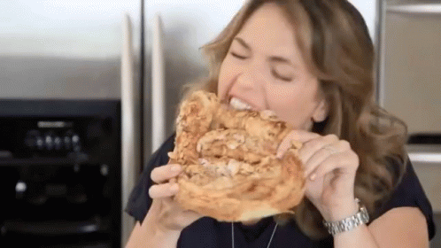 A Woman Wearing A Watch Is Eating A Piece Of Bread GIF
