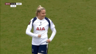a woman wearing a white aia jersey stands on a field