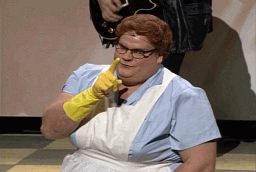 A Woman Wearing A White Apron And Yellow Gloves Is Pointing At The Camera GIF