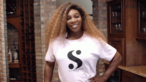 A Woman Wearing A White Compton T-Shirt Smiles GIF