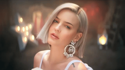 A Woman Wearing A White Dress And Earrings Has A Tattoo On Her Arm That Says ' I Love You ' GIF