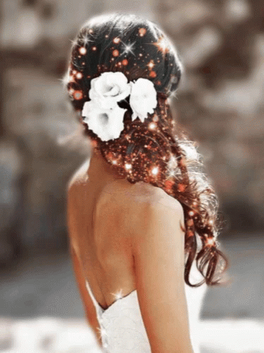 A Woman Wearing A White Dress Has Flowers In Her Hair GIF
