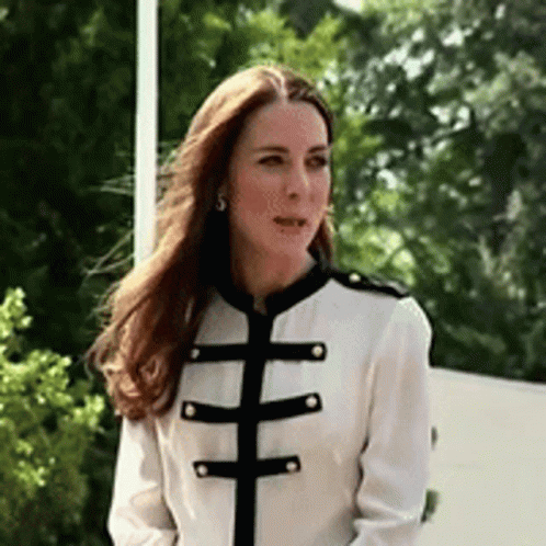 A Woman Wearing A White Jacket With Black Stripes On The Sleeves GIF