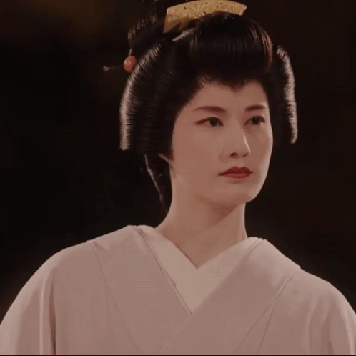 A Woman Wearing A White Kimono And A Black Hairdo GIF