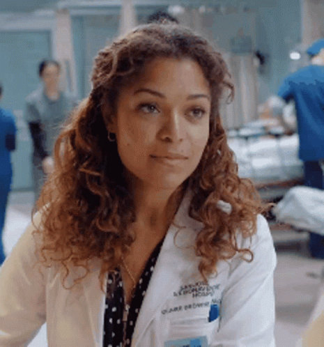 A Woman Wearing A White Lab Coat With The Name Claire Devore On It GIF