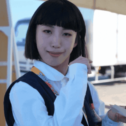 A Woman Wearing A White Shirt And A Black Vest Has A Lanyard Around Her Neck That Says ' Tokyo ' GIF