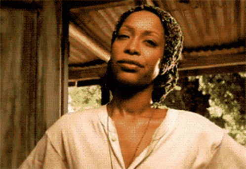 A Woman Wearing A White Shirt And A Scarf Around Her Head GIF