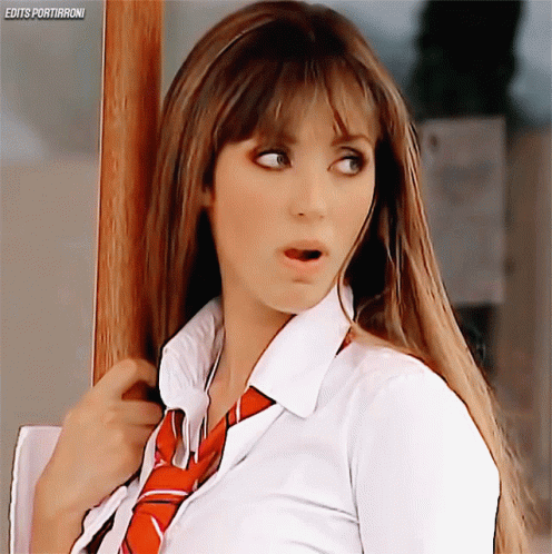 A Woman Wearing A White Shirt And Red Tie Is Standing In Front Of A Sign That Says Edits Portiaroni GIF