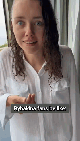 a woman wearing a white shirt is standing in front of a window with the caption rybakina fans be like