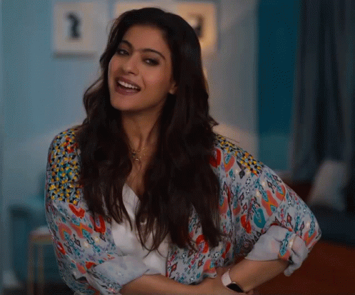 A Woman Wearing A White Shirt With A Floral Pattern On The Sleeves Is Smiling GIF