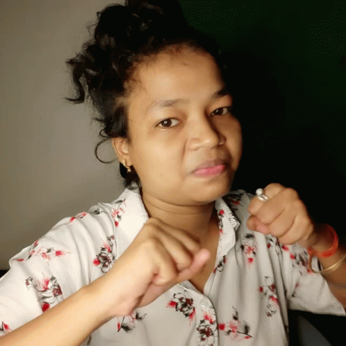 A Woman Wearing A White Shirt With Flowers On It GIF