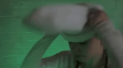A Woman Wearing A White Sweater And A White Hat With A Face On It . GIF