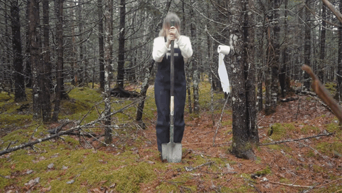 A Woman Wearing A White Sweater And Black Apron Has The Letter T On Her Apron GIF