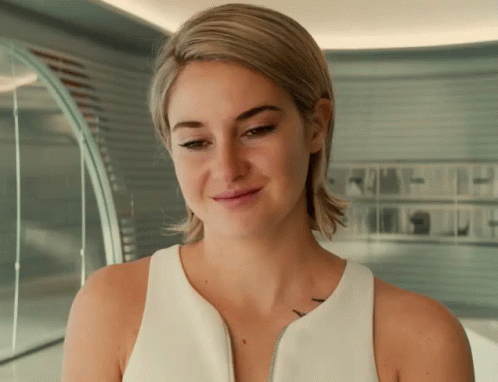 A Woman Wearing A White Tank Top Has A Tattoo On Her Shoulder GIF