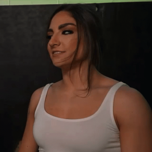 A Woman Wearing A White Tank Top Looks To The Side GIF