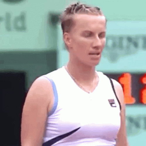A Woman Wearing A White Tank Top With A Fila Logo On The Front GIF