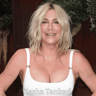 A Woman Wearing A White Tank Top With The Name Kesha Tanked On The Bottom GIF